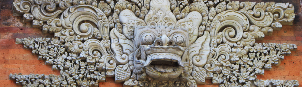 A Boma mask Lempad carved into the lintel of a gate in the outer courtyard. As you can see the outline and features stand out clearly against the intricate background.